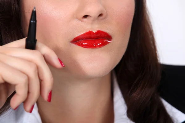 Affärskvinna bär rött läppstift och hålla pennan — Stockfoto