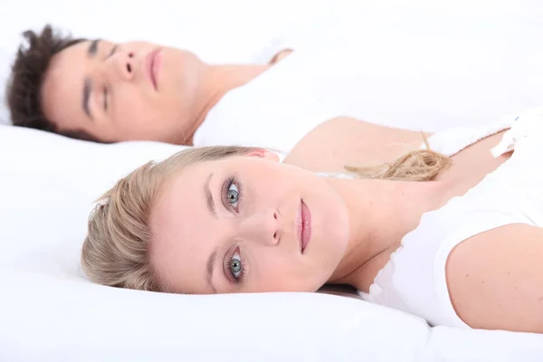 Muž a žena v posteli s očima otevřenýma — Stock fotografie