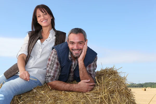 耕作对夫妇坐在干草堆上 — 图库照片