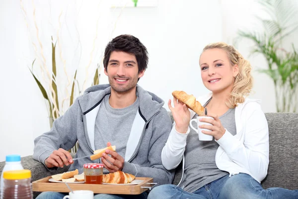 Giovani coppie che condividono la colazione nel salone — Foto Stock