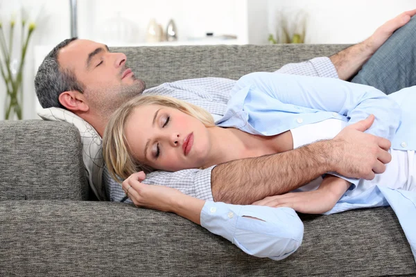 Marido e mulher dormindo em seu sofá — Fotografia de Stock