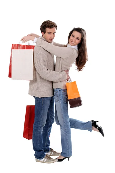Casal com sacos de compras abraçando — Fotografia de Stock