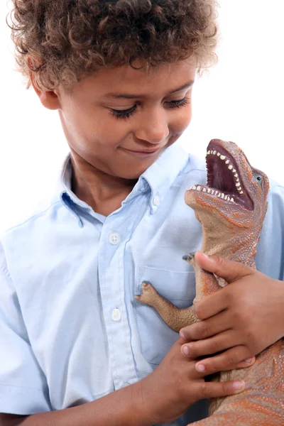 Маленький хлопчик грає з динозавром — стокове фото