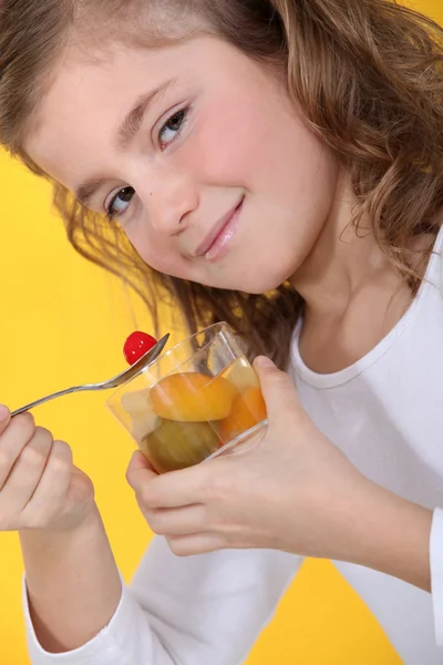 Klein meisje eten fruitsalade — Stockfoto