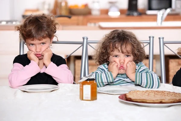 Kids pouting in the kitchen — Stock Photo, Image