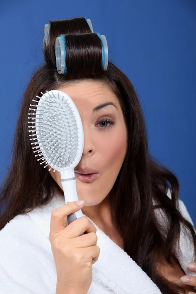 Αστεία γυναίκα με μαλλιά οδοστρωτήρες και βούρτσα — Φωτογραφία Αρχείου