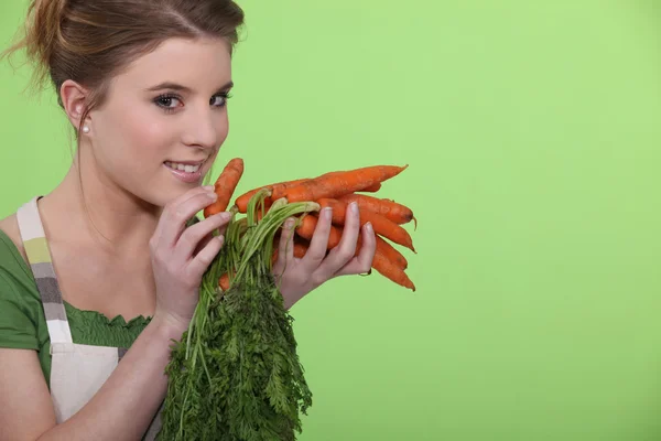 Mujer sosteniendo racimo de zanahorias — Foto de Stock