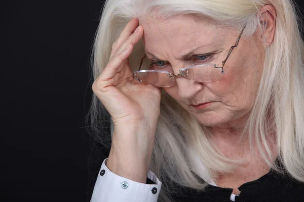 Alte Dame leidet unter Kopfschmerzen — Stockfoto