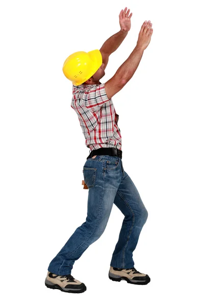 Tradesman levantando um objeto invisível — Fotografia de Stock