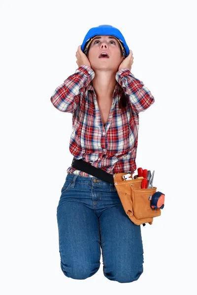 Kulaklarını kapsayan bir kadın inşaat işçisi. — Stok fotoğraf
