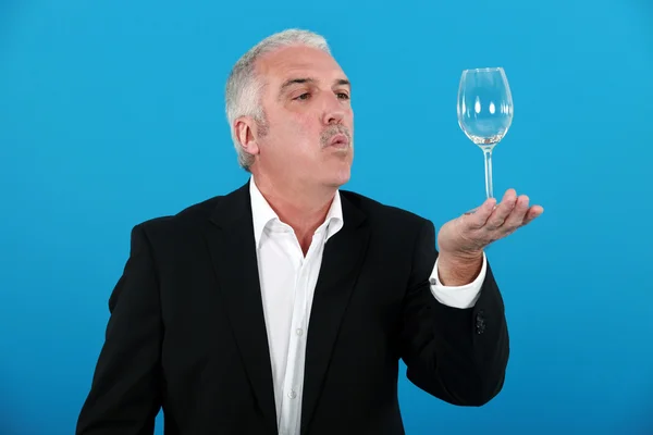 Muž foukání sklenice na víno — Stock fotografie