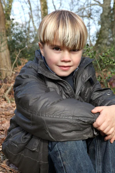 年轻的男孩坐在秋季森林 — 图库照片