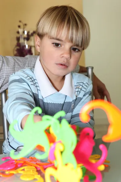 Νεαρό αγόρι που παίζει με τα πολύχρωμα σχήματα — Φωτογραφία Αρχείου