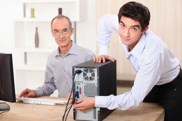 Nieto ayudando a su abuelo con la computadora —  Fotos de Stock