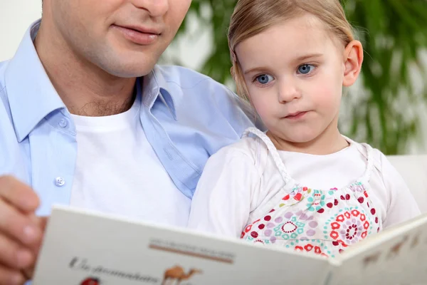 Pai lendo uma história para sua filha — Fotografia de Stock