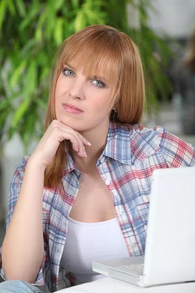 Boos vrouw die op haar laptop werkt — Stockfoto