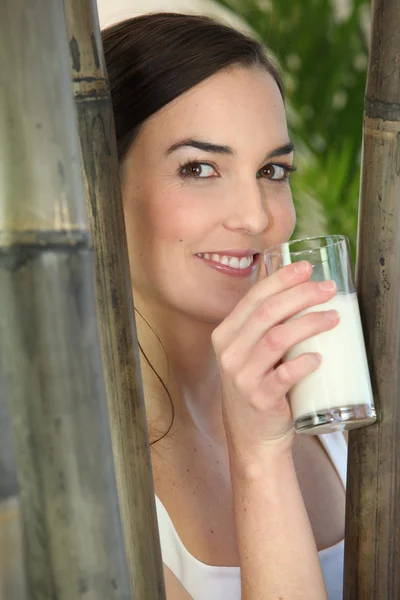 Jonge vrouw die melk drinkt — Stockfoto
