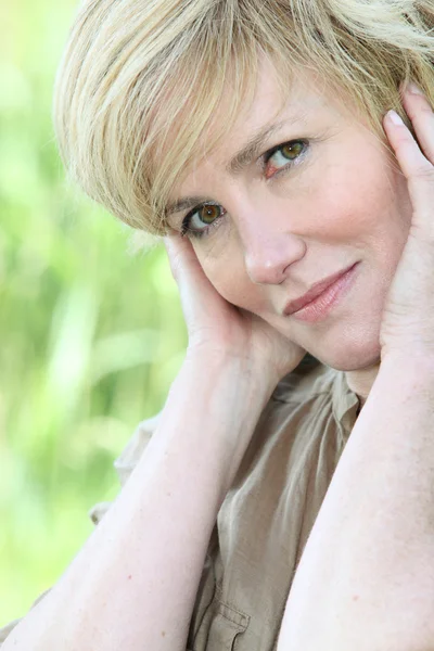 Portret blond kobieta z rąk do twarzy — Zdjęcie stockowe