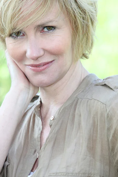 Närbild av en leende kvinna med kort blont hår — Stockfoto