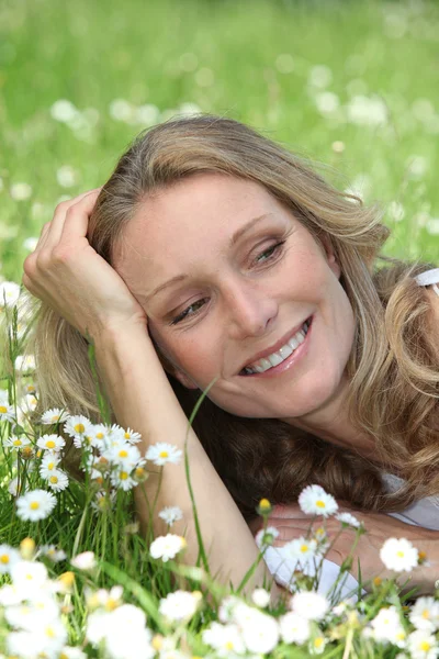Close-up van lachende vrouw onder de madeliefjes — Stockfoto
