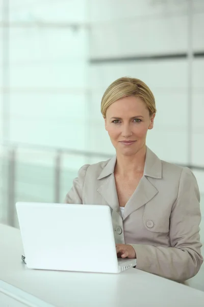 Smart woman working at a white laptop computer — Stockfoto