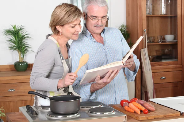 Senior couple reading a recipe book — Stock Photo, Image