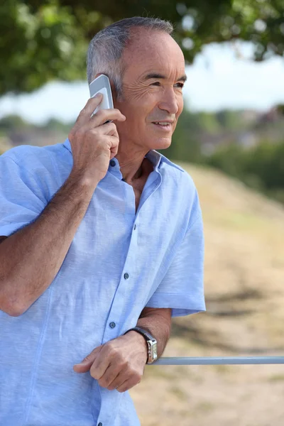 Äldre man med hjälp av en mobiltelefon — Stockfoto