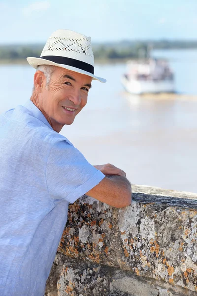 Smiling senior man watching the ferry from Blaye citadel, France — Stock Photo, Image