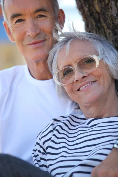 公園の木に立って高齢者のカップル — ストック写真