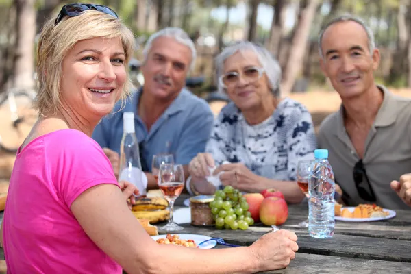 Ältere Freunde essen im Freien — Stockfoto