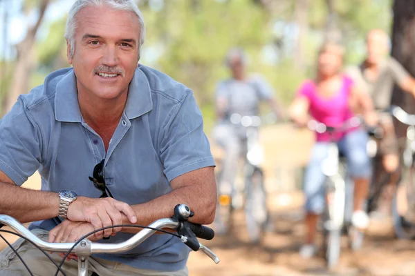 友人と乗る自転車を持つ退職者 — ストック写真