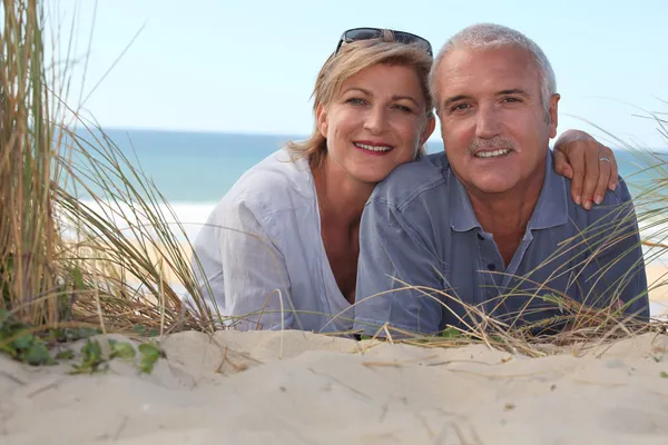 Par som ligger på stranden — Stockfoto