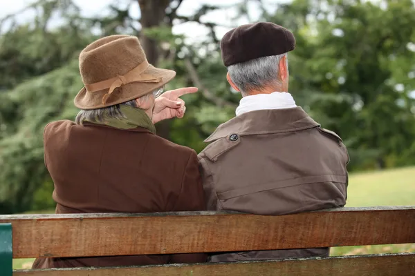 公園のベンチに座っている年配のカップル — ストック写真
