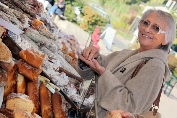 Frau kauft Brot am Marktstand — Stockfoto