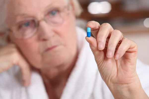 Una anciana tomando una pastilla . — Foto de Stock