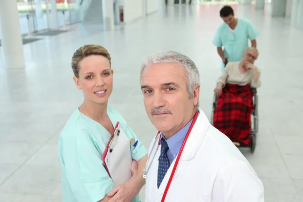 Уверенный врач и медсестра в коридоре клиники — стоковое фото