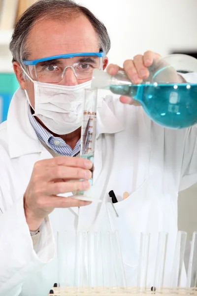 Χημικός που ρίχνει ένα υγρό σε ένα δοκιμαστικό σωλήνα — Φωτογραφία Αρχείου