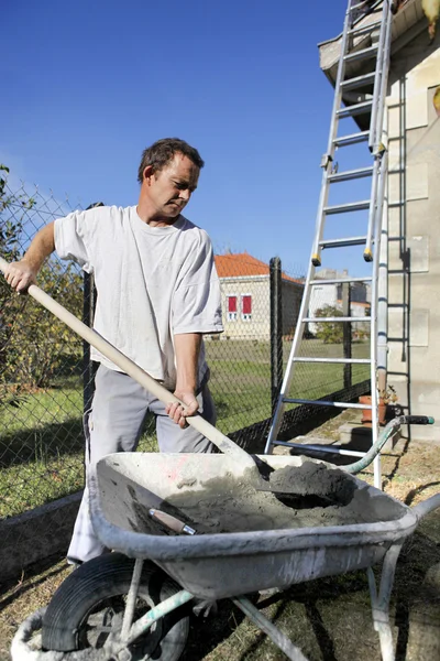 Man shoveling cement — Stockfoto