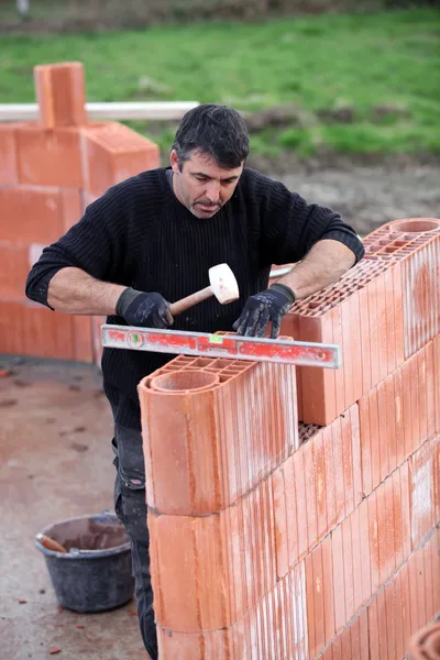 Homme érigeant un mur de briques — Photo