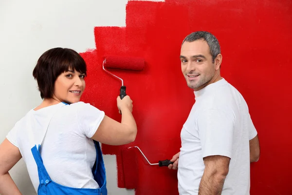 Married couple painting wall Stock Picture