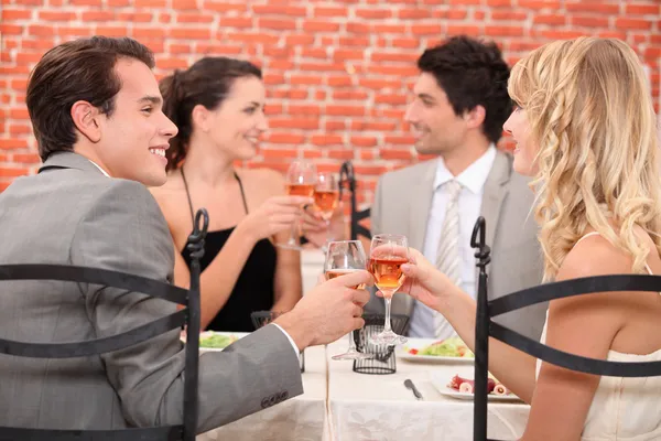 Des amis levant leurs verres dans un toast dans un restaurant — Photo