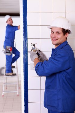 Man fixing an electrical outlet clipart