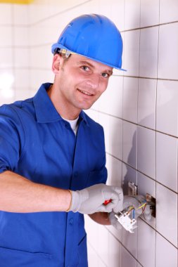 Electrician wiring a large tiled room clipart