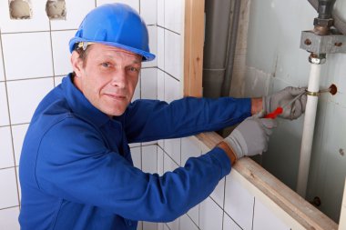 Plumber fixing water supply in bathroom clipart