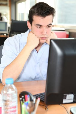 Frustrated student in front of his computer clipart