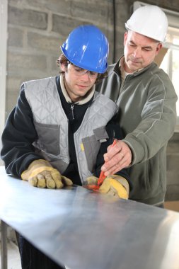 Apprentice and foreman on construction site clipart