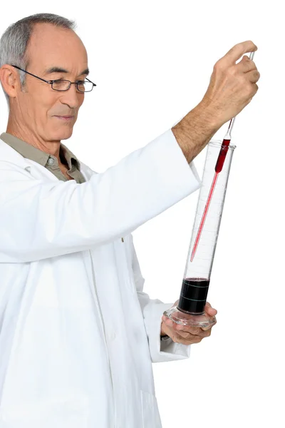 Homem de cabelos grisalhos testando vinho — Fotografia de Stock