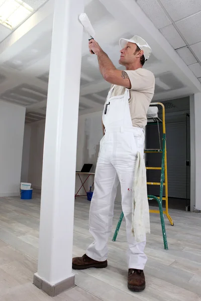 Comerciante pintando una columna — Foto de Stock