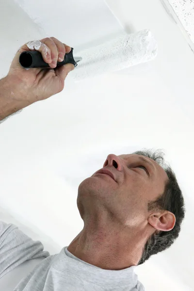 Homem pintura teto com rolo — Fotografia de Stock