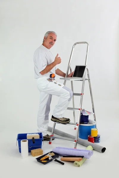 Мужчина-декоратор с лестницей, показывающей большие пальцы вверх — стоковое фото